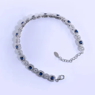 צמיד טניס כסף עם אבני סאפריר, עיצוב אלגנטי וסגנון מתוחכם, מושלם לסיטונאות תכשיטים.