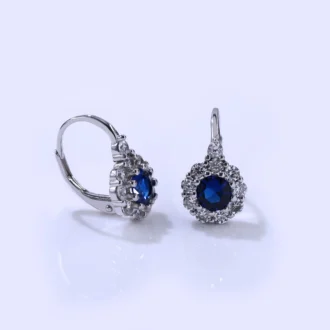 עגילים צמודים מכסף עם אבן כחולה ומסביבם קישוטי אבנים, מושלמים לסיטונאות תכשיטים.